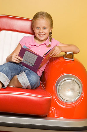 Happy Girl Reading at the Pediatric Dentist Office in Casa Grande, Mesa and Chandler, AZ